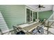 Relaxing covered patio with ceiling fan and comfortable seating, ideal for outdoor dining and entertaining at 5560 Alpine Dr, Summerville, SC 29483
