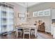 Cozy dining room with chandelier, dark hardwood floors, striped curtains, and many windows for natural light at 5560 Alpine Dr, Summerville, SC 29483