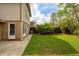 The backyard features a trimmed lawn, a concrete patio, greenery, and a wood fence at 5573 Betty Ct, North Charleston, SC 29418