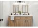 Bathroom with double sink vanity with quartz countertops, wood cabinets, and framed mirrors at 5573 Betty Ct, North Charleston, SC 29418