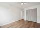 Bedroom with wood floors, white walls, ceiling fan, and sliding door closet at 5573 Betty Ct, North Charleston, SC 29418