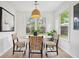 Bright dining area features modern light fixture, white walls, wood floors, and natural light from the window at 5573 Betty Ct, North Charleston, SC 29418
