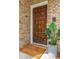 A wood front door features a large welcome mat and a potted plant at 5573 Betty Ct, North Charleston, SC 29418
