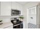 Bright kitchen features stainless steel appliances, white cabinets, quartz counters, and modern tile floor at 5573 Betty Ct, North Charleston, SC 29418
