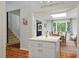 View from island to dining room with skylight, wood table, and wood floors at 597 Oyster Rake Dr, Kiawah Island, SC 29455