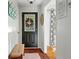 Inviting entryway featuring a dark door, wood floors, and a charming bench at 597 Oyster Rake Dr, Kiawah Island, SC 29455