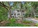 Inviting home with a covered porch nestled among mature trees and lush greenery at 597 Oyster Rake Dr, Kiawah Island, SC 29455
