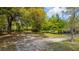 Backyard featuring a small outbuilding, large trees and sandy ground at 617 Hampton St, Walterboro, SC 29488