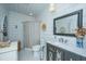 Stylish bathroom with shiplap walls, dark vanity, patterned shower curtain, and tiled floors at 617 Hampton St, Walterboro, SC 29488