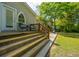 Charming home exterior featuring a wooden porch, arched windows, and lush landscaping, blending classic design with natural beauty at 617 Hampton St, Walterboro, SC 29488
