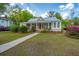 Charming home with a metal roof, inviting front porch with rocking chairs, and lush landscaping at 617 Hampton St, Walterboro, SC 29488