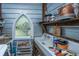 Functional laundry area with a vintage sink, storage solutions, and a charming arched window, blending practicality with character at 617 Hampton St, Walterboro, SC 29488