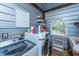 Well-equipped laundry room with modern washer and dryer, plus storage shelves and a unique arched window at 617 Hampton St, Walterboro, SC 29488