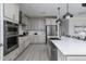 Modern kitchen featuring stainless steel appliances, gray cabinets, and a large island with a white countertop at 630 Coral Bells Ln, Summerville, SC 29486