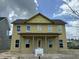 Two-story home featuring a welcoming porch and large windows, with construction in progress under a bright blue sky at 715 Blueway Ave, Summerville, SC 29486