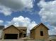 Unfinished two-story home with garage featuring exposed plywood against a partly cloudy blue sky at 721 Blueway Ave, Summerville, SC 29486