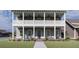 Charming two-story home with double porches, ceiling fans, rocking chairs and a landscaped front yard at 721 Blueway Ave, Summerville, SC 29486