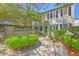 Charming two-story home with lush landscaping, stone patio, and classic black shutters offers inviting curb appeal at 73 Anson St, Charleston, SC 29401
