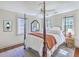 Serene bedroom with four-poster bed, hardwood floors, and ample natural light, creating a relaxing retreat at 73 Anson St, Charleston, SC 29401
