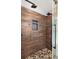 Bathroom shower featuring dual shower heads, river rock flooring, and wood-look tile at 8499 Falling Leaf Ln, North Charleston, SC 29420