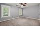 Neutral bedroom featuring carpet, ceiling fan, and two windows at 8499 Falling Leaf Ln, North Charleston, SC 29420