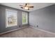 Bright bedroom featuring neutral carpet, ceiling fan, and two windows at 8499 Falling Leaf Ln, North Charleston, SC 29420