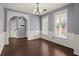 Bright dining room with dark wood floors, white wainscoting, a chandelier, and large windows at 8499 Falling Leaf Ln, North Charleston, SC 29420