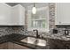 Stainless steel kitchen sink with granite countertop and mosaic backsplash at 8499 Falling Leaf Ln, North Charleston, SC 29420