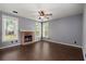 Cozy living room featuring dark wood floors, a brick fireplace, neutral paint, and plenty of natural light at 8499 Falling Leaf Ln, North Charleston, SC 29420