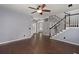 Spacious living room with dark wood floors, staircase with white spindles, and neutral paint at 8499 Falling Leaf Ln, North Charleston, SC 29420