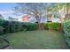 Fenced backyard with a mix of grass, weeds, and a mature tree at 9028 Parlor Dr, Ladson, SC 29456