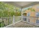 Cozy covered balcony with wood floors overlooking trees and a yellow building at 9028 Parlor Dr, Ladson, SC 29456