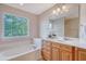 Bathroom featuring soaking tub and double vanity with bright natural light from large window at 9028 Parlor Dr, Ladson, SC 29456