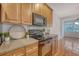 Kitchen area with natural wood cabinets, tile backsplash, and black oven/microwave appliance set at 9028 Parlor Dr, Ladson, SC 29456