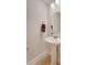 Small powder room with pedestal sink, round mirror, and tiled floor at 9028 Parlor Dr, Ladson, SC 29456