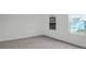 A cozy bedroom with neutral walls, carpet, and a view of a light blue home at 1014 Marsh Harrier Dr # Cc3-1-5, Ravenel, SC 29470