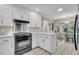 Modern kitchen with white cabinets, stainless steel appliances, and an open layout to the dining area at 109 Dan Miler Ln, Summerville, SC 29483