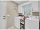 Laundry room with tile floors and plenty of storage space, plus a window for natural light at 109 Dan Miler Ln, Summerville, SC 29483