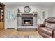 Living room fireplace with a brick hearth, a decorative mantle, and hardwood flooring at 109 Dan Miler Ln, Summerville, SC 29483