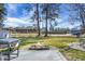 This expansive backyard offers mature trees, a fire pit, an outdoor kitchen area and a baseball field in the background at 1113 Smithfield Pl, Hanahan, SC 29410