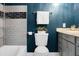 Bathroom with blue walls, gray tiled shower and vanity area featuring a marble countertop and dark gray cabinets at 1113 Smithfield Pl, Hanahan, SC 29410