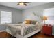 Bright bedroom with a decorative white bed frame, ceiling fan, wood floors, blinds and an orange dresser at 1113 Smithfield Pl, Hanahan, SC 29410