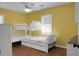 Bedroom features white bunkbeds, a ceiling fan and bright yellow walls for a cheerful and inviting atmosphere at 1113 Smithfield Pl, Hanahan, SC 29410