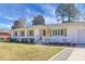 Attractive painted-brick home with a tidy lawn and garden beds under a bright blue sky at 1113 Smithfield Pl, Hanahan, SC 29410