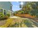 Lush backyard with green grass, wooden fence, and screened-in porch connected to the house at 1213 Captain Rivers Dr, Charleston, SC 29412