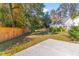 Backyard featuring green space, wood fence, detached garage, and mature trees at 1213 Captain Rivers Dr, Charleston, SC 29412