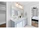 This double vanity bathroom features grey cabinetry, a large mirror, and an entrance to a bedroom at 1213 Captain Rivers Dr, Charleston, SC 29412