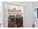 Modern laundry room with a stacked washer and dryer, plus convenient shelving for storage at 1213 Gatch Ct, Mount Pleasant, SC 29464