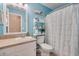 A light blue bathroom with a white vanity, toilet, and shower-tub, perfect for a refreshing and calm experience at 1306 Markley Ct, Moncks Corner, SC 29461