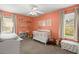 A cozy bedroom painted in a light orange with a white crib, multiple storage spaces, and windows for natural light at 1306 Markley Ct, Moncks Corner, SC 29461